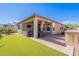 Low maintenance backyard with a built-in BBQ, artificial turf, and a covered patio at 20641 W College Dr, Buckeye, AZ 85396