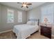 Cozy bedroom with wood-look floors, a comfortable bed, and plantation shutters at 20641 W College Dr, Buckeye, AZ 85396