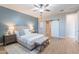 Well-lit bedroom with wood-look floors, leading to a white sliding barn door to the bathroom at 20641 W College Dr, Buckeye, AZ 85396
