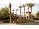Welcoming community entrance with mature palm trees and classic architecture promoting an inviting community at 20641 W College Dr, Buckeye, AZ 85396