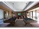 A luxurious game room featuring pool tables, seating areas, and multiple TVs for entertainment at 20641 W College Dr, Buckeye, AZ 85396