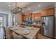 Modern kitchen featuring stainless steel appliances, a breakfast bar, and stylish granite countertops at 20641 W College Dr, Buckeye, AZ 85396