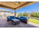 Inviting covered patio features comfortable seating, built-in grill, and lush backyard views at 20641 W College Dr, Buckeye, AZ 85396