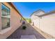 View of the side yard featuring a gravel landscape, small trees, and a walkway at 20641 W College Dr, Buckeye, AZ 85396
