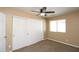 Bedroom with tan walls, neutral carpet, ceiling fan, and a closet with sliding doors at 2213 W Marconi Ave, Phoenix, AZ 85023