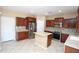 Well-lit kitchen features stainless steel appliances, tile flooring, wood cabinets, and a kitchen island at 2213 W Marconi Ave, Phoenix, AZ 85023