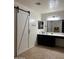 Modern bathroom with barn door entry, dual sinks, and updated fixtures at 23890 W Twilight Trl, Buckeye, AZ 85326