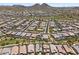 Expansive aerial view of a community featuring tile-roofed homes, pools, desert landscaping, and mountain views at 26943 N 74Th Ave, Peoria, AZ 85383