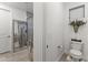 Clean bathroom with a glass shower stall, wood-look tile, and a modern toilet with funny decoration at 26943 N 74Th Ave, Peoria, AZ 85383