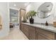 Bright bathroom with double sinks, framed circular mirrors, a glass shower, and dark wooden cabinets at 26943 N 74Th Ave, Peoria, AZ 85383