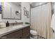 Well-lit bathroom with modern vanity, neutral colors, and shower with stylish curtain at 26943 N 74Th Ave, Peoria, AZ 85383