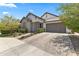 Attractive single-story home with a two-car garage, paver driveway, stone accents, and desert landscaping at 26943 N 74Th Ave, Peoria, AZ 85383