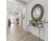 Bright and airy hallway featuring wood-look tile, a decorative mirror, and glass console table with plant decor at 26943 N 74Th Ave, Peoria, AZ 85383