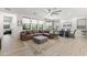 Inviting living room area featuring a large leather couch, modern tile floors, and sunlit windows at 26943 N 74Th Ave, Peoria, AZ 85383