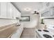 Kitchen features white cabinets, modern appliances, and ceiling fan at 3208 W Port Royale Ln, Phoenix, AZ 85053