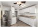 Bright kitchen with stainless steel refrigerator, white cabinets, and tile floors at 3208 W Port Royale Ln, Phoenix, AZ 85053