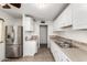 Bright kitchen featuring white cabinetry, stainless steel refrigerator, and modern countertops at 3208 W Port Royale Ln, Phoenix, AZ 85053