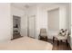 Neutral toned bedroom with seating area, closet, and door to bathroom at 35990 N Desert Tea Dr, Queen Creek, AZ 85140