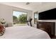 Bright bedroom with a large window, wood floors, and a TV at 35990 N Desert Tea Dr, Queen Creek, AZ 85140