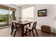 Bright dining area with dark wood table and chairs; natural light from sliding glass doors at 35990 N Desert Tea Dr, Queen Creek, AZ 85140