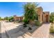 Stylish home exterior with a well-manicured desert landscape, brick driveway, and modern architectural details at 35990 N Desert Tea Dr, Queen Creek, AZ 85140