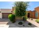 Charming home exterior with a well-maintained desert landscape, brick driveway, and a two-car garage at 35990 N Desert Tea Dr, Queen Creek, AZ 85140