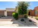 Charming home exterior with a well-maintained desert landscape, brick driveway, and two-car garage at 35990 N Desert Tea Dr, Queen Creek, AZ 85140
