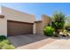 Beautiful home with a brown garage door, brick driveway, and desert landscaping in a desirable location at 35990 N Desert Tea Dr, Queen Creek, AZ 85140
