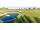 Picturesque golf course pond with green grass, a rock shoreline, and clear blue water on a sunny day at 35990 N Desert Tea Dr, Queen Creek, AZ 85140