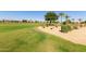 Picturesque golf course view with vibrant green grass, mature trees, and well-maintained landscaping in a residential area at 35990 N Desert Tea Dr, Queen Creek, AZ 85140