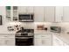 Bright kitchen features stainless steel appliances, white cabinetry and marble countertops at 35990 N Desert Tea Dr, Queen Creek, AZ 85140