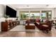 Bright living room with large windows, a comfortable leather couch, and a decorative area rug at 35990 N Desert Tea Dr, Queen Creek, AZ 85140