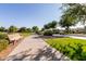 Picturesque community pathway lined with green grass, shade trees, and park benches for relaxing at 35990 N Desert Tea Dr, Queen Creek, AZ 85140