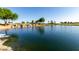 Picturesque pond with cascading waterfall, blue water, and lush green surroundings on a sunny day at 35990 N Desert Tea Dr, Queen Creek, AZ 85140