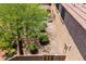 Aerial view of landscaped backyard with desert rock, green shrubbery, and a desert tree providing shade at 3760 W Lapenna Dr, New River, AZ 85087
