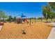 Community playground featuring colorful equipment, swings, and a wood chip ground, offering a fun and safe space at 3760 W Lapenna Dr, New River, AZ 85087