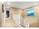Upstairs hallway with carpeting, white railing, and a window with a view of the outdoors at 3760 W Lapenna Dr, New River, AZ 85087