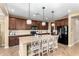 Beautiful kitchen with granite counters, wood cabinets, black appliances, and center island with seating at 3760 W Lapenna Dr, New River, AZ 85087
