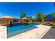 Backyard pool and patio with umbrellas, outdoor kitchen and lounge chair at 3760 W Lapenna Dr, New River, AZ 85087