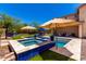 Relaxing backyard with a sparkling pool, tanning deck, and multiple umbrellas for shade on sunny days at 3760 W Lapenna Dr, New River, AZ 85087