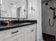 Modern bathroom featuring a dark countertop, white cabinets, a large mirror, and a walk-in shower at 4117 E Coolidge St, Phoenix, AZ 85018