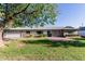 Single story home with a large tree in the front yard and a blue front door at 4117 E Coolidge St, Phoenix, AZ 85018