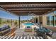 Inviting outdoor kitchen and grill area near the pool, with an inviting fire pit and desert views at 41809 N La Crosse Trl, Anthem, AZ 85086