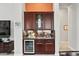 Butler's pantry with wine fridge, custom cabinetry, and granite countertop next to the kitchen at 41809 N La Crosse Trl, Anthem, AZ 85086