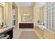 Large bathroom offering dark wood cabinets, tiled floors, soaking tub, and a glass block shower at 41809 N La Crosse Trl, Anthem, AZ 85086