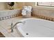 Close-up of a pristine white bathtub with a chrome faucet and decorative tile surround at 41809 N La Crosse Trl, Anthem, AZ 85086