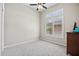 Bright bedroom offers neutral paint, carpet, and ceiling fan with plenty of natural light from the windows at 41809 N La Crosse Trl, Anthem, AZ 85086