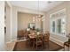 Elegant dining room with modern chandelier, wood table set, and view to the side yard at 41809 N La Crosse Trl, Anthem, AZ 85086