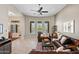 Bright living room featuring leather sofas, tile floors, and large windows with backyard pool view at 41809 N La Crosse Trl, Anthem, AZ 85086