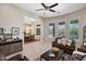 Inviting living room showing tile floors, leather seating, view to dining room, and backyard at 41809 N La Crosse Trl, Anthem, AZ 85086